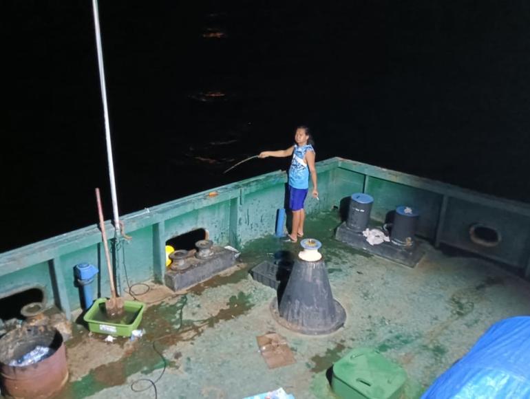 An abandoned seafarer fishing off the side of his ship for food